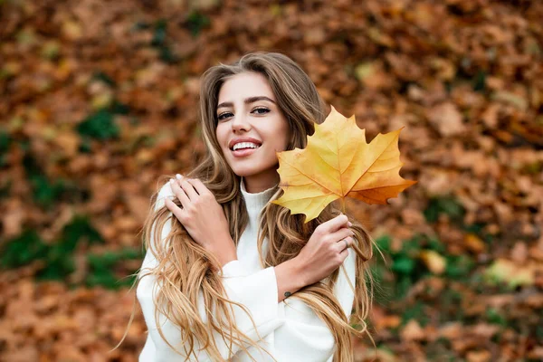 Donna alla moda che ride nel parco autunnale. Bella ragazza riccia spensierata in abito alla moda sorridente godere di riposo. Divertente ritratto biondo nel parco, concetto di caduta. Autunno all'aperto. — Foto Stock