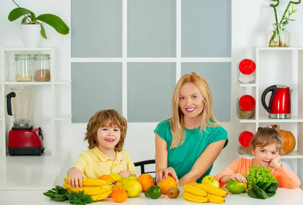 Молода мама і двоє її дітей їдять фрукти і п'ють смузі, концепція дня матерів, здорове харчування вдома . — стокове фото