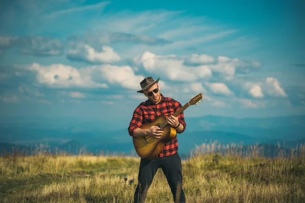 Cowboy western men. Young guy plays guitar at sky. — Stock Photo, Image