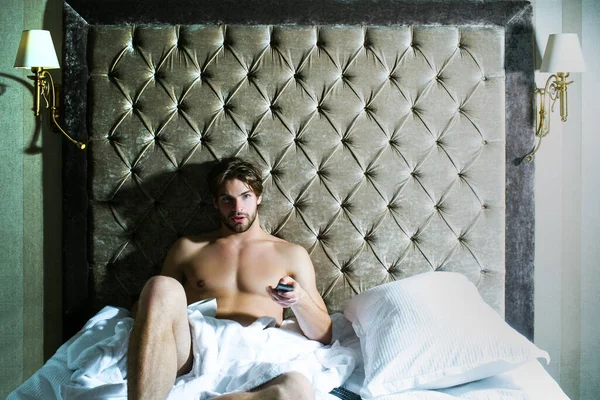 Un ragazzo spensierato che si gode la mattina. Uomo a torso nudo in camera da letto. Bello uomo in biancheria intima seduto sul letto. — Foto Stock