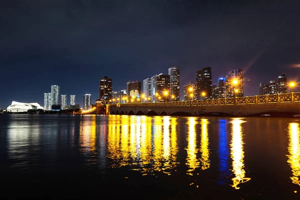 Miami, Florida, USA városnézés Biscayne Bay-en, városi éjszakai háttérrel. Miami Florida, naplemente panoráma színes megvilágított üzleti és lakóépületek és híd Biscayne Bay. — Stock Fotó