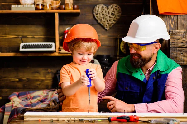 Vader en zoon leren timmermansgereedschap gebruiken. Jongen met vader die samen een houten huis bouwt. Vaderschap concept. — Stockfoto