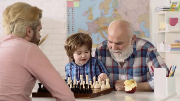 Miúdos da escola privada. Avô Pai e filho menino jogando xadrez em casa. Crianças jogos educativos, desenvolvimento precoce. Jogos e atividades para crianças. Conceito familiar. — Vídeo de Stock