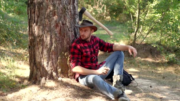 Holzfäller im Wald mit einer Axt. Bärtiger Mann mit Axt-Konzept. Holzfäller mit Axt auf Waldhintergrund. Der Mensch macht seinen Job. Holzernte. — Stockvideo