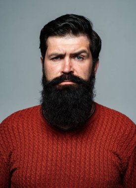 Kendine güvenen adamın sakalı ve bıyığı var. Ciddi ve izole görünüyor. Hipster ciddi adam ifadeyle düşünüyor. Yakışıklı erkek model, yakın çekim yüzü..