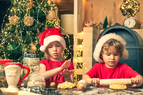 Kinder kochen für Weihnachten. Weihnachtsgebäck. Lustige Kinder bereiten in der Küche den Teig mit Mehl zu. — Stockfoto