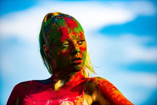 Färg ansikte flicka med färgglada holi stänk. Porträtt av en ung flicka målad i färgpulver. — Stockfoto