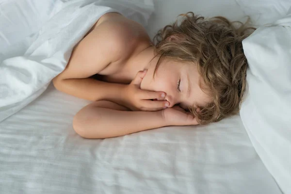 Chlapeček spí na posteli. Dítě spí v posteli. — Stock fotografie