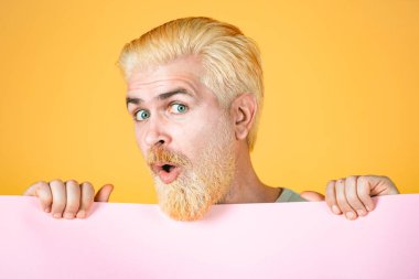 Elinde kocaman bir tabela tutan adam. Boşluğu kağıda kopyala. Elinde boş bir kağıt parçası tutan bir adam. İzole edilmiş arkaplanda renkli bir stüdyo resmi.