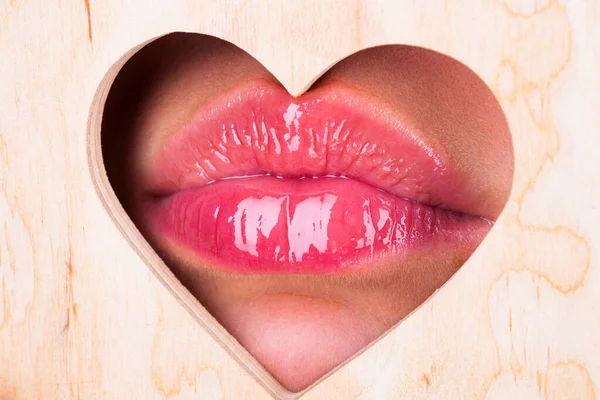 Heart shape. Girl Natural beauty lips. Red lip with glossy lipgloss. Close up, macro with beautiful mouths. Sexy kiss, sensual seductive lips of a young woman. Cosmetics and beauty salon. — Stock Photo, Image