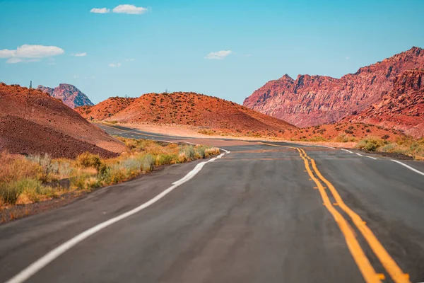 Asfaltweg dwars door het veld met blauwe lucht in de herfst. Amerikaanse roadtrip. — Stockfoto