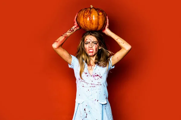 Dziewczyna z dynią. Zombie. Żądza krwi. Halloween kobieta na czerwonym tle odizolowany. Pełen krwi.. — Zdjęcie stockowe