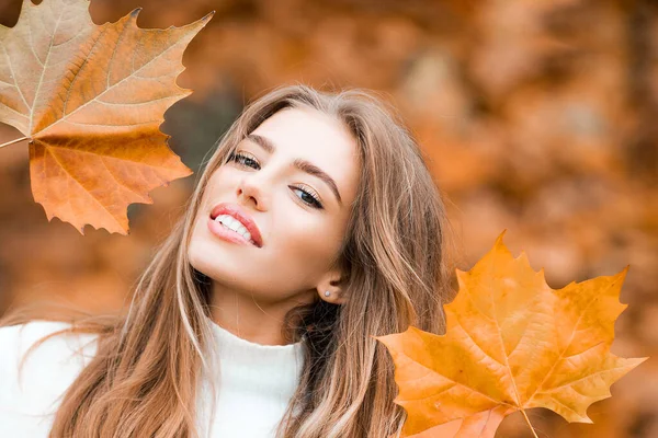Woman with autumn leaves. Girl with orange leaves. Season and autumn holiday. Beauty and fashion. Smiling model with stylish hair. — Stock Photo, Image
