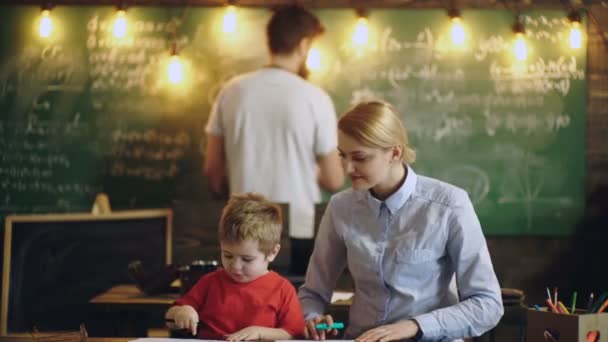 Famiglia che fa i compiti insieme a casa. Festa degli insegnanti. Genitori insegnanti che aiutano gli alunni a studiare in classe. Genitori e figli. — Video Stock