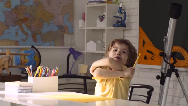 Glückliches, nettes, fleißiges Kind sitzt drinnen an einem Schreibtisch. Individueller Unterricht. — Stockvideo