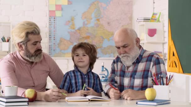 Отец, дедушка и сын после школы преподают. Школьный ребенок или дошкольник учиться с родителями. — стоковое видео