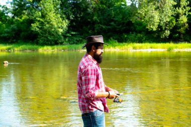 Fishman büyük balığı beklerken nehre örgü ördü. Adam sakallı balıkçı. Avlanıyordum. Balıkçı ekipmanları. Ruh hobisi. Erkek hobisi. Olgun adam balık tutuyor. Hobi ve eğlence.