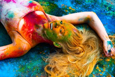 Renkli yüzlü genç kadınlar Holi renk festivalini kutluyor.
