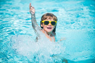 Mutlu çocuk yüzme havuzunda eğleniyor.