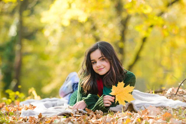 Šťastná dospívající dívka venku na podzimním poli. Roztomilá dospívající dívka ležící na podzimním javorovém listí na podzim venku. Krásný podzimní čas v přírodě. — Stock fotografie
