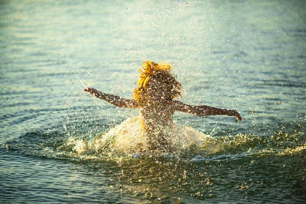 Wazig bewegingssilhouet van een gelukkig kind dat in zee speelt. Kind heeft plezier op zee buiten. Zomervakantie en gezond levensstijl concept. — Stockfoto