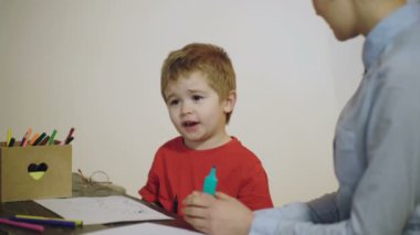 İlkokul. Anne ve küçük oğlu evde oynuyorlar..