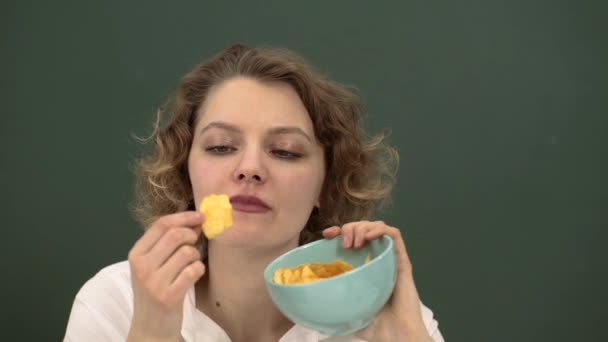 Female student eating chips. Woman eating crispy chips snack. — Stock Video