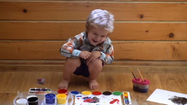 Barnteckningar. ett barn som ritar bläck, fingerfärger, handavtryck. — Stockvideo