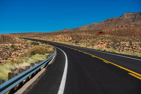 Landschaft mit orangefarbenen Felsen, Himmel mit Wolken und Asphaltstraße im Sommer. Amerikanischer Roadtrip. — Stockfoto