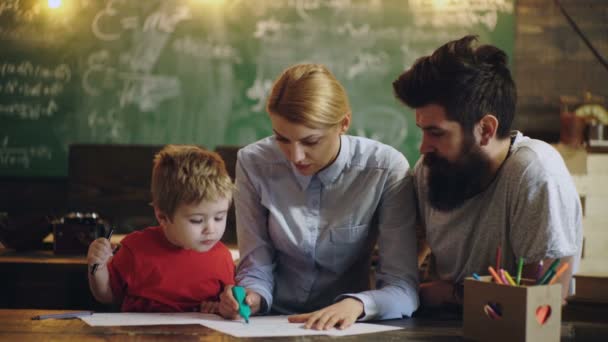 Rodina doma studuje a učí se domácí úkoly. Roztomilý chlapeček s rodiči. Zpátky do školy a šťastný čas pro děti. — Stock video