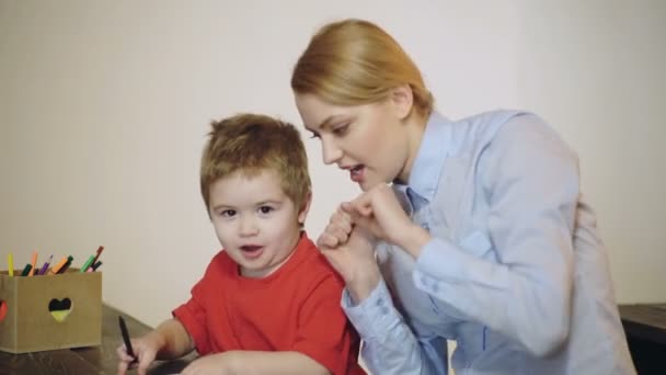 Een kleuter. schattig zoontje met moeder het hebben van plezier en met behulp van verf. — Stockvideo