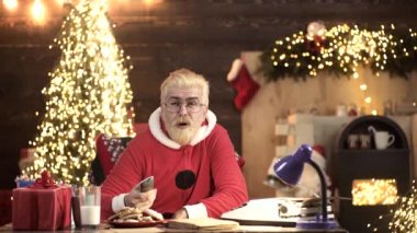 Noel Baba evde oturup Noel ağacının yanında uzaktan kumandayla televizyon izler. Komik Noel Baba.