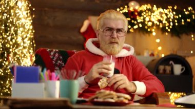 Noel Baba için süt ve zencefilli kurabiye, Noel Baba şöminenin yanındaki evinde ve Noel ağacı koltukta dinleniyor..