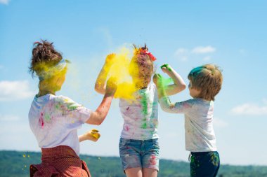 Parlak yaz renkleri. Bir grup çocuk renkli toz ve toz tozuyla oynamaktan zevk alıyor..