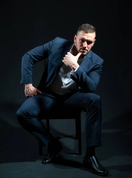 Retrato de hombre vestido con un traje azul posando en estudio negro. —  Fotos de Stock