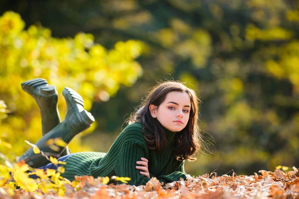 Jong tiener meisje in herfststijl jurk poseren op rood esdoorn blad achtergrond buiten. — Stockfoto