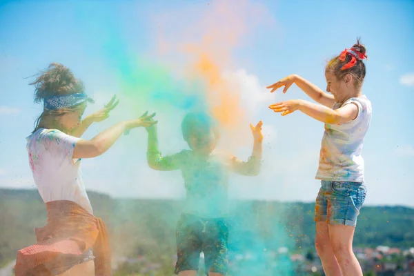 Grupo de niños disfrutando jugando con polvo de colores y salpicaduras de polvo de color. —  Fotos de Stock