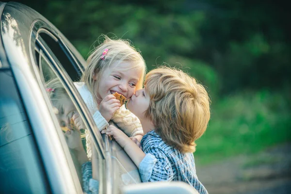 Lustiges Pärchen, das sich vor der Autofahrt verabschiedet. Tschüss. Abschiedskonzept. Kleiner Junge gibt warmen Kuss. Abschied vor der Autofahrt. — Stockfoto