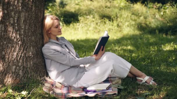 Étudiant fille lecture livre dans parc à l'extérieur. — Video