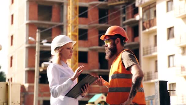 Twee vrouwelijke inspecteurs en architecten discussiëren met hoofdingenieur over bouwproject. — Stockvideo