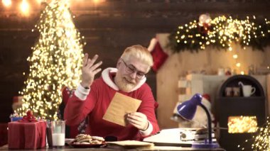 Modern Noel Baba istek listesi mektubu okuyor.