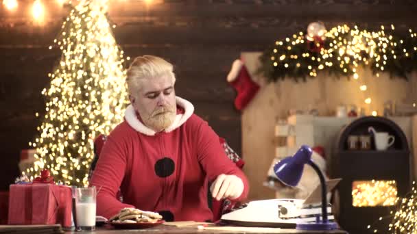 Moderno Santa Claus leyendo la lista de deseos mágicos en su casa de madera. La magia de la Navidad. — Vídeos de Stock