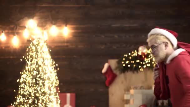 Święty Mikołaj niosący torbę. Zabawny współczesny Mikołaj. Dom dla Mikołaja. — Wideo stockowe