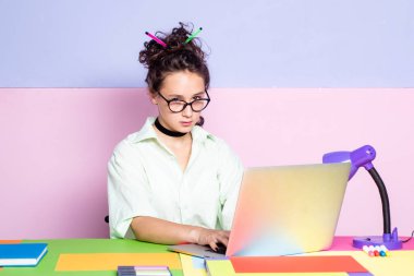 Sınıftaki komik öğrenci kız. Hipster ergen kız öğrenci internette notlar yazıyor. Bilgisayarda Webinar öğreniyor. Mesafe kazanma kursu, evde video konferansı.