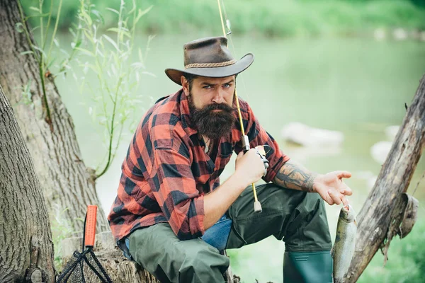 Homem de pesca relaxante enquanto desfruta de hobby. Passatempo masculino. Lar de passatempos. Voar aventuras de pesca. Pescador maduro alegre pesca em um rio ao ar livre. Homem barbudo e elegante. Angler pegar o peixe. — Fotografia de Stock