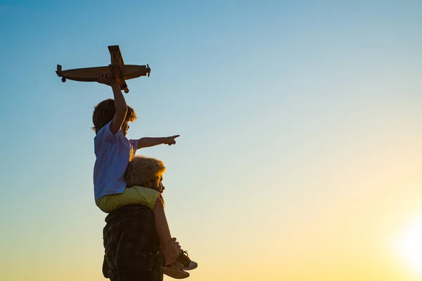 Sunset silhouette of Happy father and kid son with airplane dreams of traveling. Happy boy child. — Stock Photo, Image
