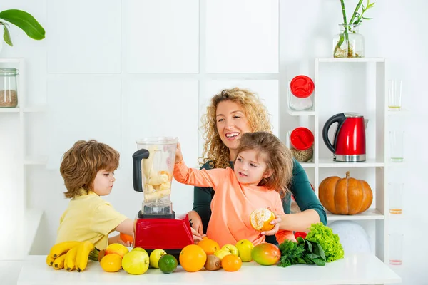 Anne ve iki çocuğu kokteyl ve meyve suyu karıştırıyor, anneler günü konsepti., — Stok fotoğraf