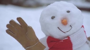 Kırmızı burunlu, kış eşarbında duran kardan adamın yüzünü kapat. Noel ve Noel 'i kutluyoruz.
