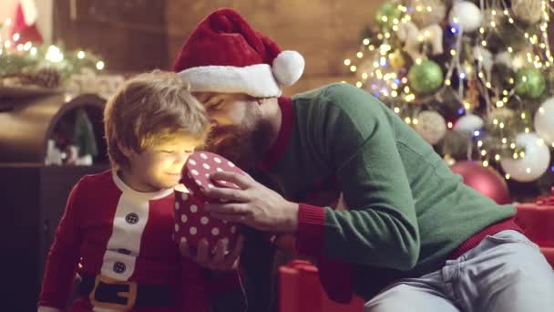 Glückliches Kind mit Vater öffnet Weihnachtsgeschenkbox. Neujahrsgeschenk für Kinder. Junge genießen den Urlaub. — Stockvideo