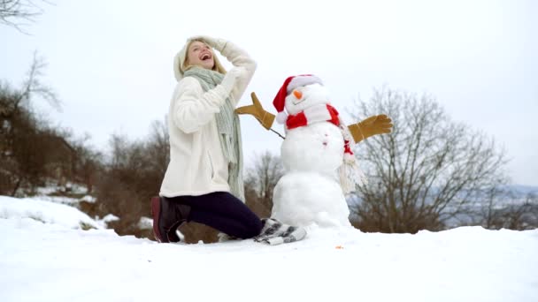 Holly joyeux swag Noël et le nez. Femme faire bonhomme de neige en plein air le jour d'hiver. — Video